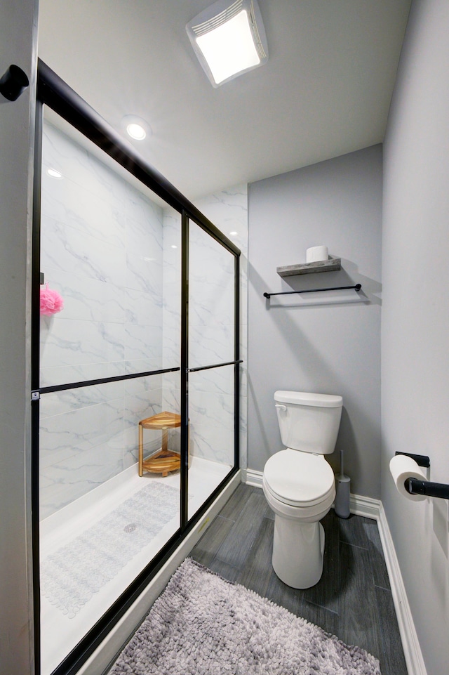 full bath with recessed lighting, toilet, a marble finish shower, baseboards, and wood finished floors