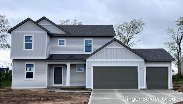 view of front of house with roof with shingles, an attached garage, concrete driveway, and board and batten siding