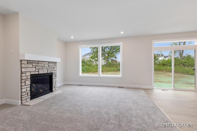 343 Seneca Ridge Dr Unit 40, Middleville, MI 49333 - unfurnished living room featuring a stone fireplace, wood finished floors, and recessed lighting