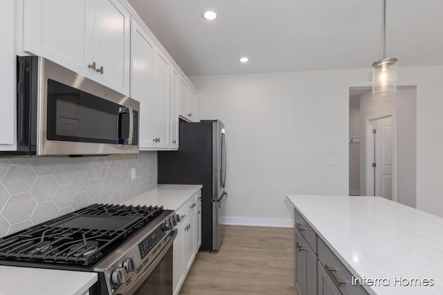 343 Seneca Ridge Dr Unit 40, Middleville, MI 49333 - kitchen with appliances with stainless steel finishes, light wood finished floors, backsplash, white cabinets, and recessed lighting
