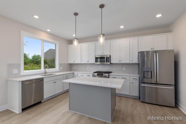 343 Seneca Ridge Dr Unit 40, Middleville, MI 49333 - kitchen featuring stainless steel appliances, light countertops, light wood-style flooring, backsplash, and white cabinetry