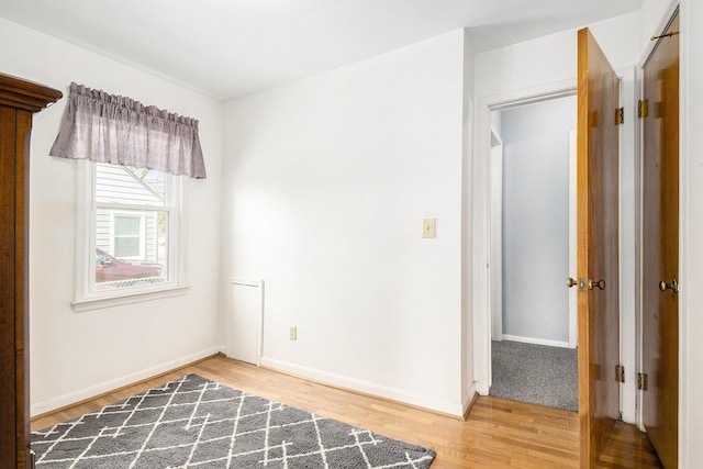 empty room featuring baseboards and light wood finished floors