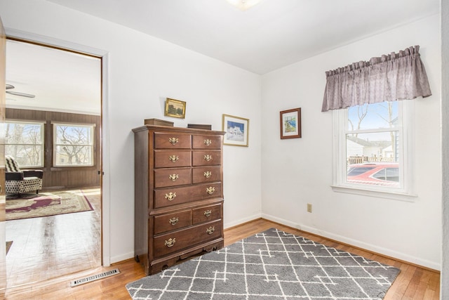 bedroom featuring baseboards, multiple windows, and hardwood / wood-style floors