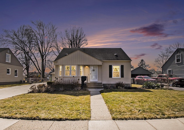 bungalow with a front yard, fence, and roof with shingles