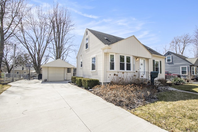 view of front of home with an outbuilding, fence, concrete driveway, a front yard, and a garage