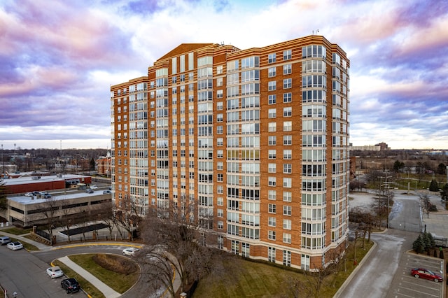 property at dusk featuring a view of apartment building / complex