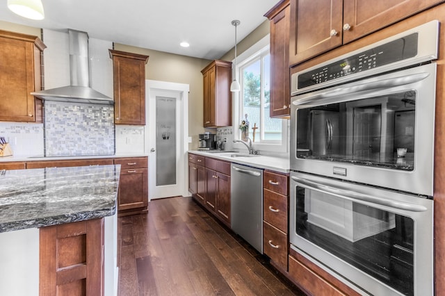 3269 Hopewell Ct NE, Rockford, MI 49341 - kitchen with wall chimney exhaust hood, appliances with stainless steel finishes, dark wood-type flooring, a sink, and pendant lighting