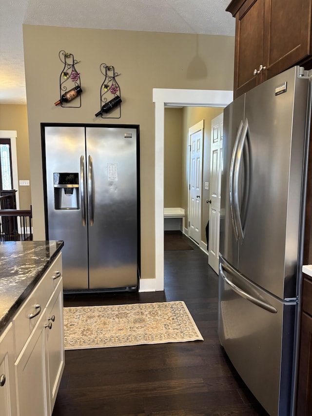 3269 Hopewell Ct NE, Rockford, MI 49341 - kitchen with stainless steel fridge, freestanding refrigerator, dark brown cabinetry, dark wood finished floors, and dark stone countertops