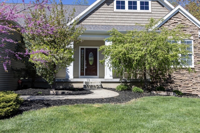 3269 Hopewell Ct NE, Rockford, MI 49341 - doorway to property with a shingled roof, a yard, and a porch