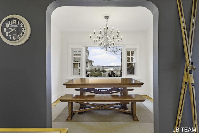 1200 Beach Dr, Holland, MI 49423 - dining space with a chandelier, arched walkways, and baseboards