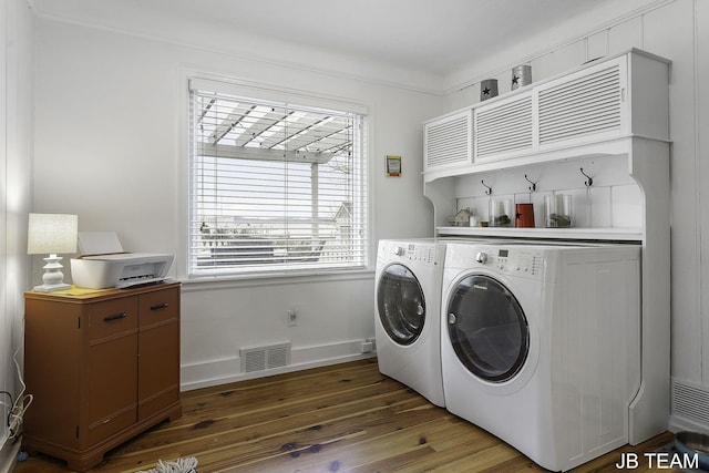 1200 Beach Dr, Holland, MI 49423 - laundry room featuring washing machine and clothes dryer, wood finished floors, cabinet space, crown molding, and baseboards