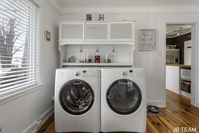 1200 Beach Dr, Holland, MI 49423 - laundry area featuring washing machine and clothes dryer, cabinet space, and wood finished floors