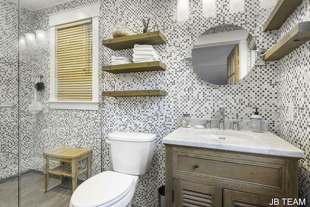 1200 Beach Dr, Holland, MI 49423 - bathroom featuring tile walls, vanity, toilet, a tile shower, and wood finished floors