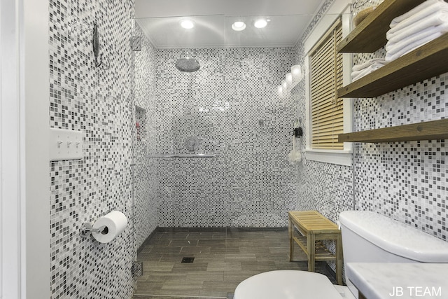 1200 Beach Dr, Holland, MI 49423 - bathroom with tile walls, toilet, a tile shower, vanity, and recessed lighting