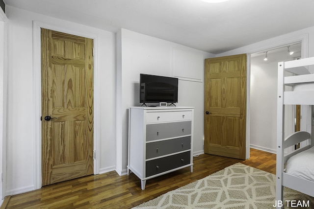 1200 Beach Dr, Holland, MI 49423 - bedroom with wood finished floors, rail lighting, and baseboards