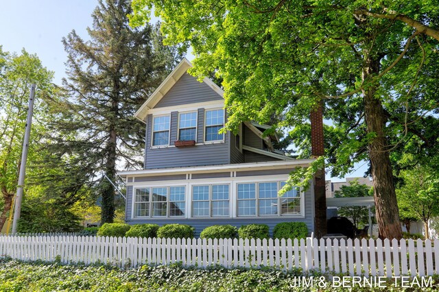 1200 Beach Dr, Holland, MI 49423 - view of front facade with a chimney and a fenced front yard