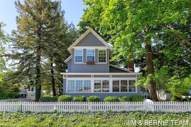 1200 Beach Dr, Holland, MI 49423 - traditional-style house with a chimney and a fenced front yard