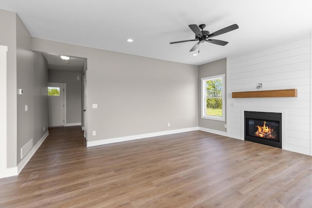 144 9 Mile Rd NW, Comstock Park, MI 49321 - unfurnished living room with healthy amount of natural light, wood finished floors, ceiling fan, recessed lighting, and a fireplace
