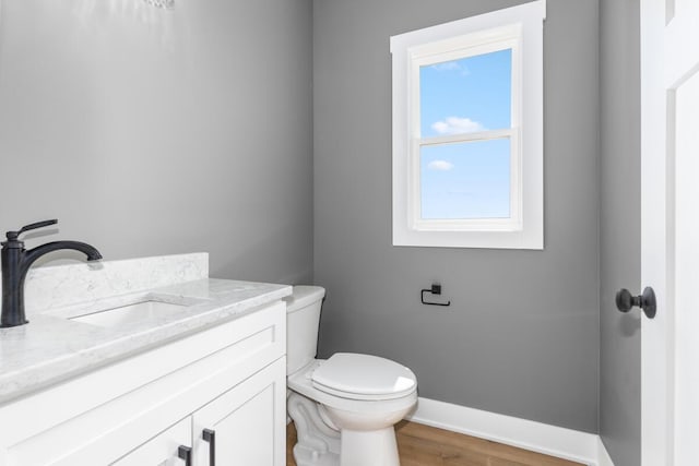 144 9 Mile Rd NW, Comstock Park, MI 49321 - half bath with toilet, baseboards, vanity, and wood finished floors