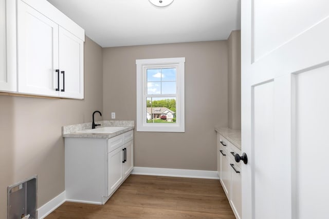 144 9 Mile Rd NW, Comstock Park, MI 49321 - laundry room featuring baseboards, wood finished floors, and a sink