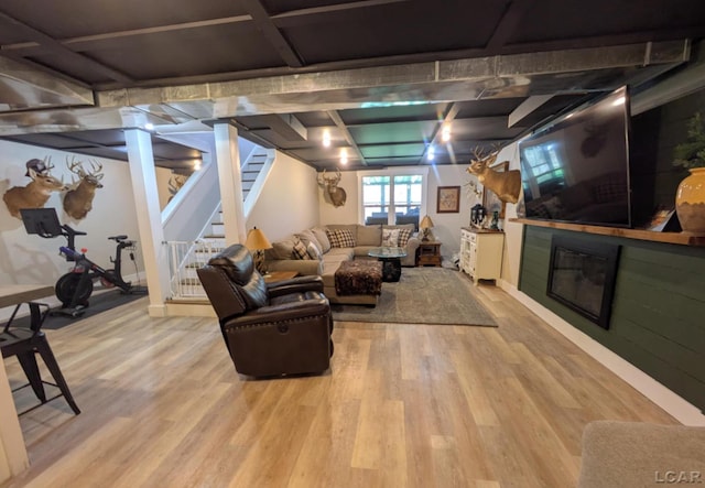 13936 Allen Rd, Clinton, MI 49236 - living area featuring a glass covered fireplace, wood finished floors, and stairs