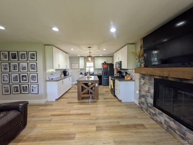 13936 Allen Rd, Clinton, MI 49236 - kitchen with black appliances, recessed lighting, white cabinetry, and light wood-style floors