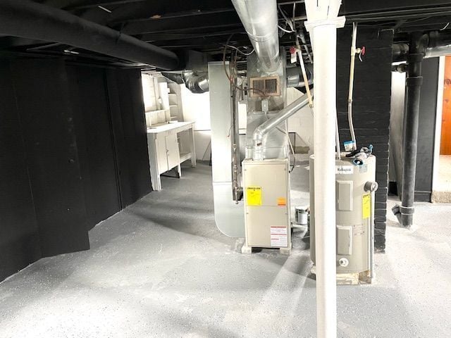 unfinished below grade area featuring water heater