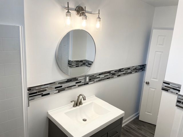 bathroom featuring decorative backsplash, vanity, and wood finished floors