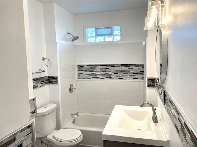 bathroom featuring tasteful backsplash, toilet, shower / bathing tub combination, and vanity