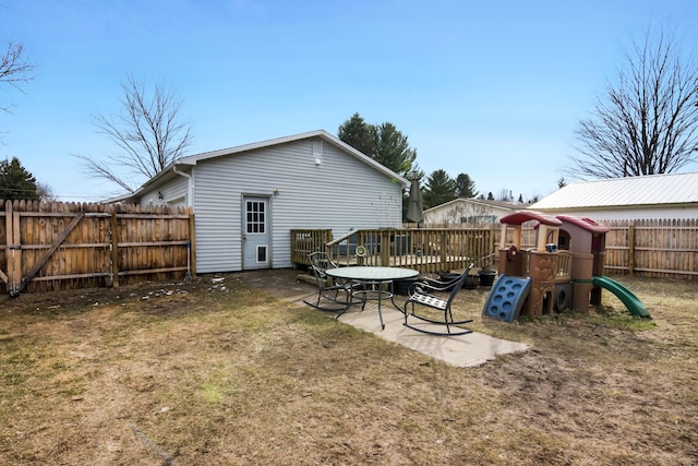 5278 W Mobile Trl, Traverse City, MI 49685 - back of house featuring a yard, a fenced backyard, and a playground