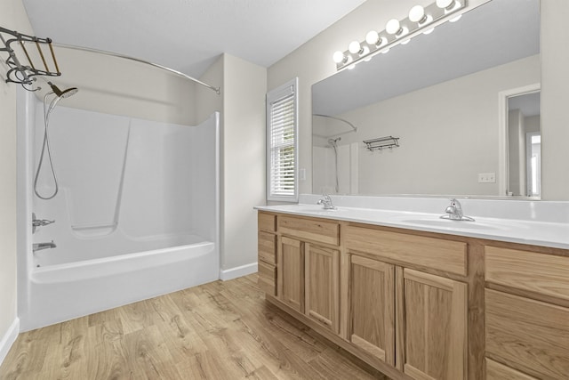 full bathroom featuring double vanity, wood finished floors, shower / bath combination, and a sink
