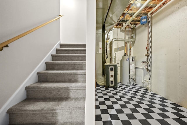 stairway with tile patterned floors, heating unit, and gas water heater