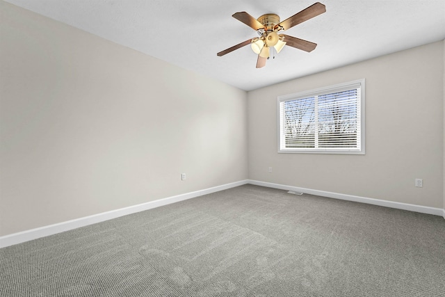 carpeted empty room featuring a ceiling fan and baseboards