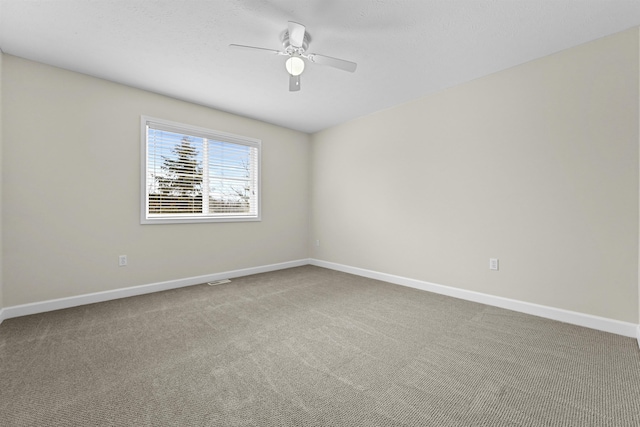unfurnished room with a ceiling fan, carpet, and baseboards