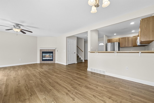 unfurnished living room with visible vents, baseboards, recessed lighting, light wood-style flooring, and a ceiling fan