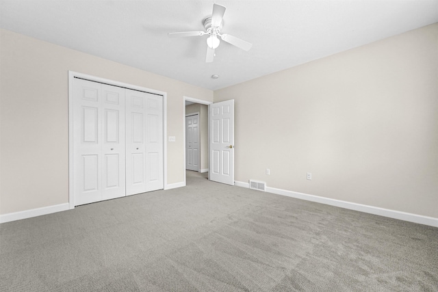 unfurnished bedroom with a closet, visible vents, baseboards, and carpet floors