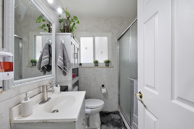 full bathroom featuring toilet, a stall shower, vanity, and tile walls