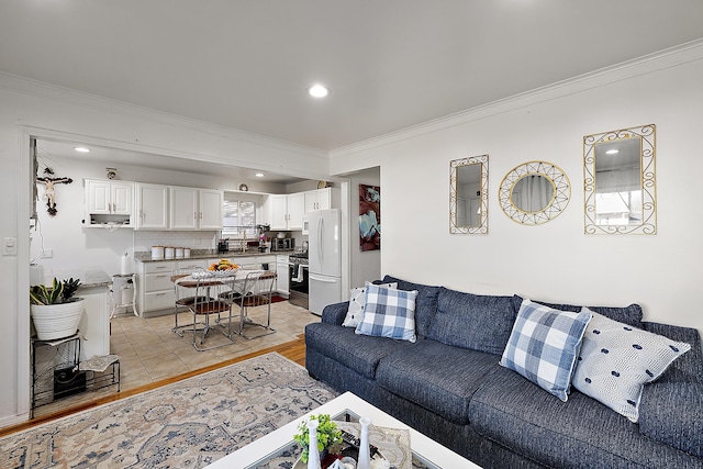 living area with recessed lighting, light wood-style flooring, and ornamental molding