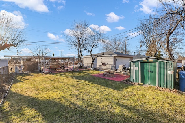 view of yard featuring a patio, fence, an outdoor structure, and a shed