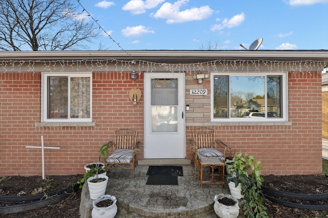 doorway to property featuring brick siding