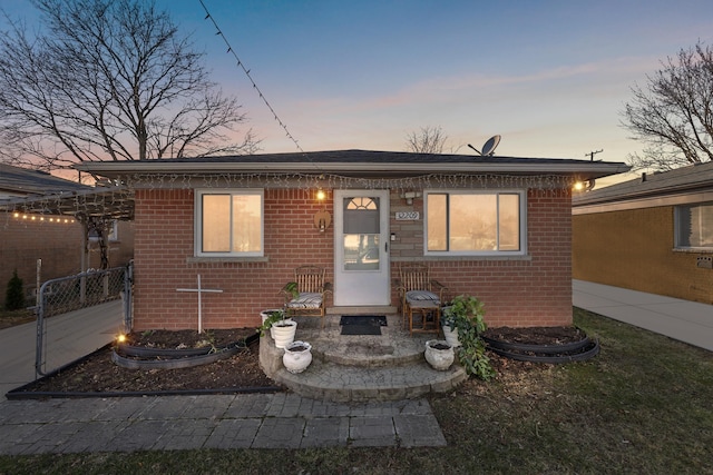 bungalow-style house with brick siding