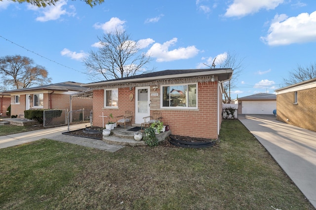 bungalow featuring brick siding, an outdoor structure, a front yard, and fence