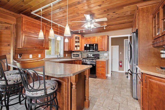 47463 Lakeview Dr, Lawrence, MI 49064 - kitchen featuring stainless steel appliances, wood ceiling, a kitchen bar, brown cabinetry, and a ceiling fan
