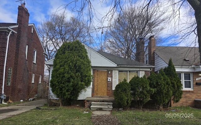 15709 Carlisle St, Detroit, MI 48205 - view of front facade with brick siding, driveway, and a front yard