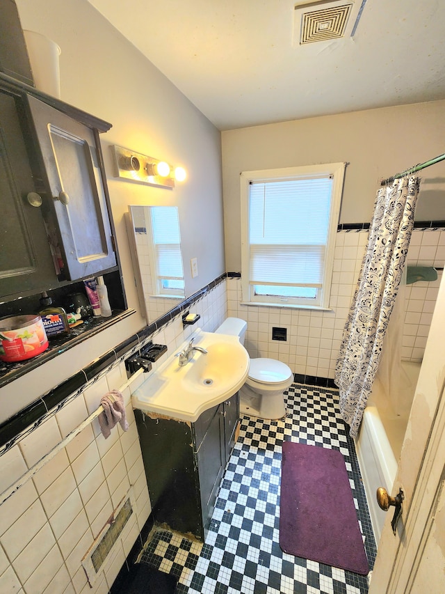 full bath with tile walls, visible vents, toilet, vanity, and wainscoting