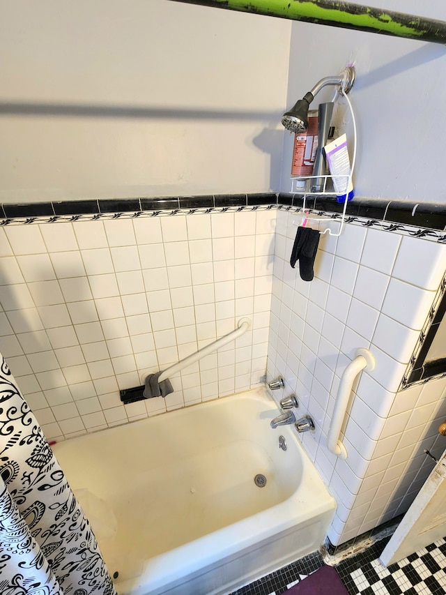 full bath featuring tile walls and shower / bathtub combination with curtain