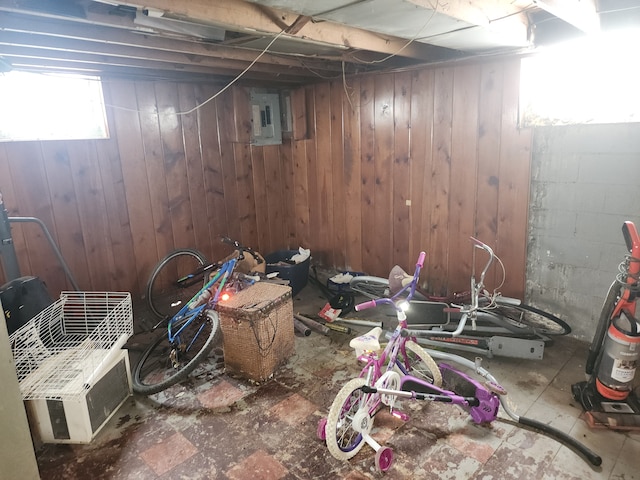 basement with wood walls and electric panel