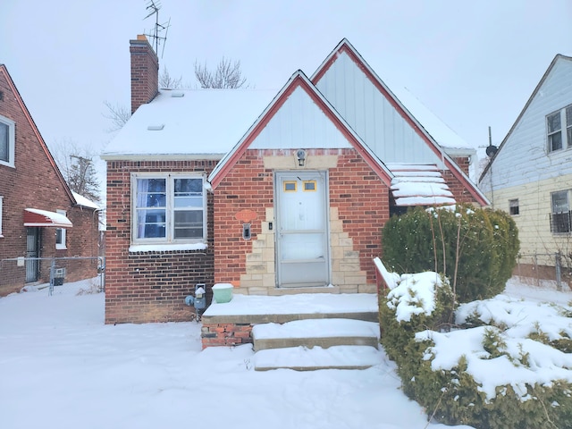 view of front of house with board and batten siding, brick siding, and a chimney