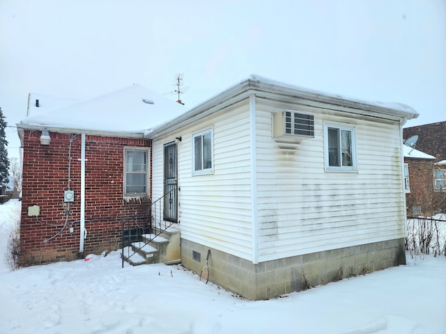 snow covered property featuring entry steps