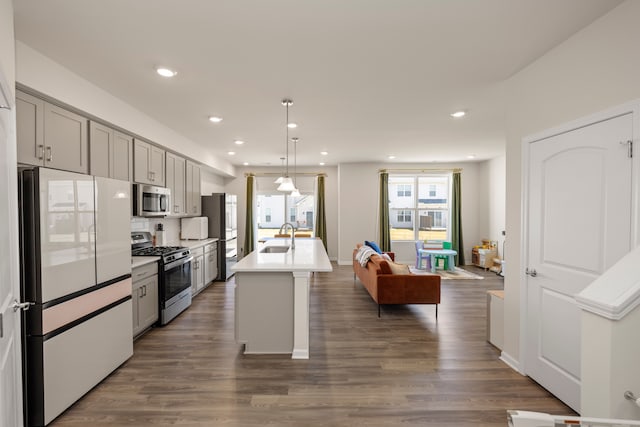 kitchen featuring light countertops, stainless steel appliances, a sink, dark wood-style floors, and gray cabinets